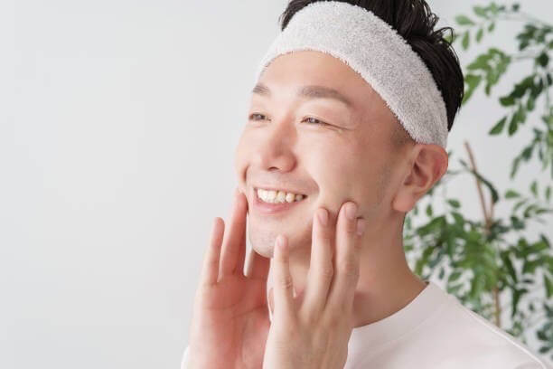 綺麗になったお肌に触れて笑っている男性