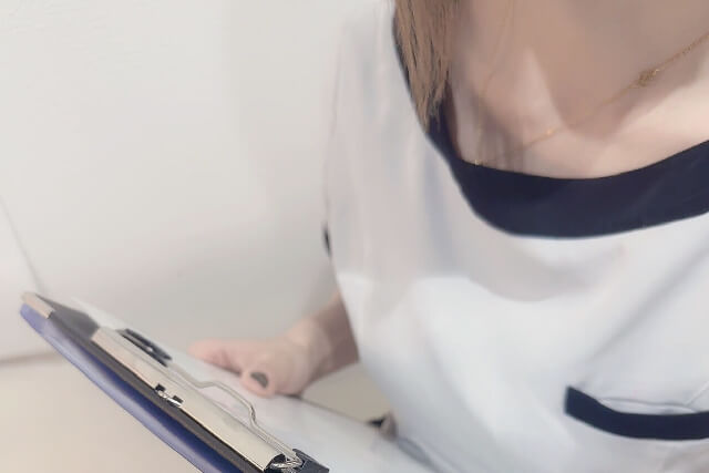 次回のことについてメモ用紙を持って接客する女性スタッフ